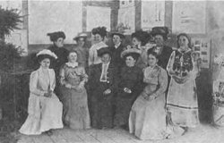 Grupa ziemianek w pawilonie rolniczym, na tle ich wystawy.